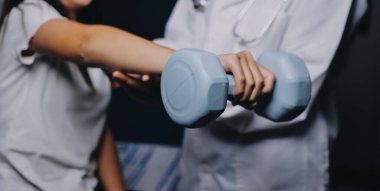 Fizyoterapistle antrenman yapan yaşlı bir kadın. Evde terapist kullanıyor. Huzurevinde yaşlı bir kadına destek oluyor.