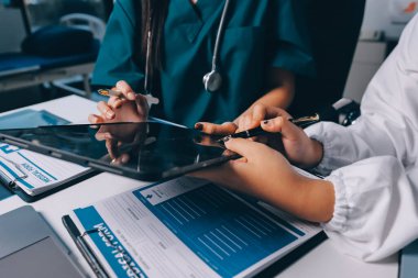 Hastane konferans salonunda kıdemli hekimin sunumu ve sağlık uygulamaları üzerine profesyonel eğitim oturumuna katılan bir grup doktor