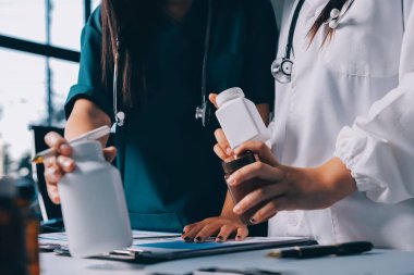 Hastane konferans salonunda kıdemli hekimin sunumu ve sağlık uygulamaları üzerine profesyonel eğitim oturumuna katılan bir grup doktor