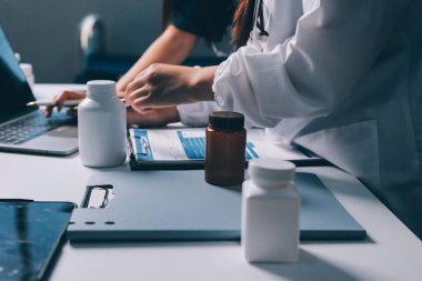 Hastane konferans salonunda kıdemli hekimin sunumu ve sağlık uygulamaları üzerine profesyonel eğitim oturumuna katılan bir grup doktor