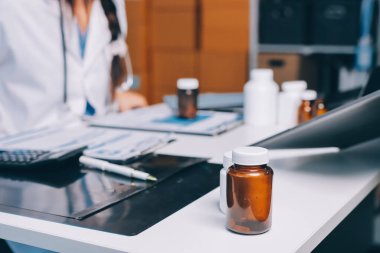 Hastane konferans salonunda kıdemli hekimin sunumu ve sağlık uygulamaları üzerine profesyonel eğitim oturumuna katılan bir grup doktor