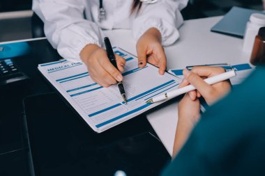 Hastane konferans salonunda kıdemli hekimin sunumu ve sağlık uygulamaları üzerine profesyonel eğitim oturumuna katılan bir grup doktor