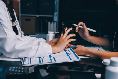 Hastane konferans salonunda kıdemli hekimin sunumu ve sağlık uygulamaları üzerine profesyonel eğitim oturumuna katılan bir grup doktor