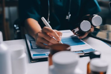 Hastane konferans salonunda kıdemli hekimin sunumu ve sağlık uygulamaları üzerine profesyonel eğitim oturumuna katılan bir grup doktor