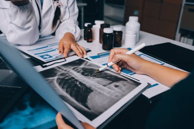 Hastane konferans salonunda kıdemli hekimin sunumu ve sağlık uygulamaları üzerine profesyonel eğitim oturumuna katılan bir grup doktor