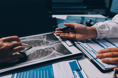 Hastane konferans salonunda kıdemli hekimin sunumu ve sağlık uygulamaları üzerine profesyonel eğitim oturumuna katılan bir grup doktor