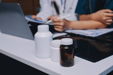 Hastane konferans salonunda kıdemli hekimin sunumu ve sağlık uygulamaları üzerine profesyonel eğitim oturumuna katılan bir grup doktor