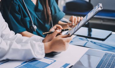 Hastane konferans salonunda kıdemli hekimin sunumu ve sağlık uygulamaları üzerine profesyonel eğitim oturumuna katılan bir grup doktor