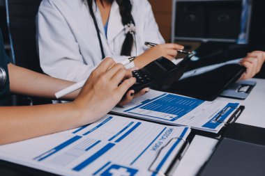 Hastane konferans salonunda kıdemli hekimin sunumu ve sağlık uygulamaları üzerine profesyonel eğitim oturumuna katılan bir grup doktor