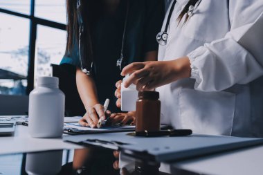 Hastane konferans salonunda kıdemli hekimin sunumu ve sağlık uygulamaları üzerine profesyonel eğitim oturumuna katılan bir grup doktor