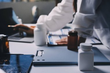 Hastane konferans salonunda kıdemli hekimin sunumu ve sağlık uygulamaları üzerine profesyonel eğitim oturumuna katılan bir grup doktor