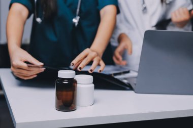 Hastane konferans salonunda kıdemli hekimin sunumu ve sağlık uygulamaları üzerine profesyonel eğitim oturumuna katılan bir grup doktor