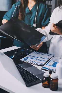 Hastane konferans salonunda kıdemli hekimin sunumu ve sağlık uygulamaları üzerine profesyonel eğitim oturumuna katılan bir grup doktor