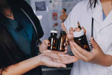 Hastane konferans salonunda kıdemli hekimin sunumu ve sağlık uygulamaları üzerine profesyonel eğitim oturumuna katılan bir grup doktor