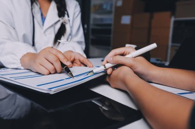 Hastane konferans salonunda kıdemli hekimin sunumu ve sağlık uygulamaları üzerine profesyonel eğitim oturumuna katılan bir grup doktor