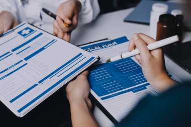 Hastane konferans salonunda kıdemli hekimin sunumu ve sağlık uygulamaları üzerine profesyonel eğitim oturumuna katılan bir grup doktor