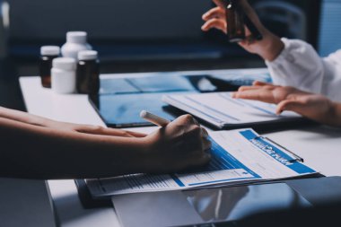 Hastane konferans salonunda kıdemli hekimin sunumu ve sağlık uygulamaları üzerine profesyonel eğitim oturumuna katılan bir grup doktor