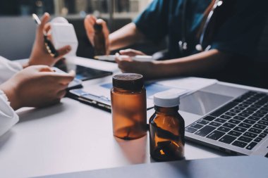 Hastane konferans salonunda kıdemli hekimin sunumu ve sağlık uygulamaları üzerine profesyonel eğitim oturumuna katılan bir grup doktor