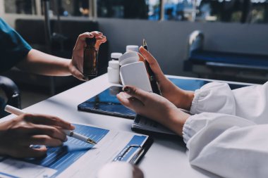 Hastane konferans salonunda kıdemli hekimin sunumu ve sağlık uygulamaları üzerine profesyonel eğitim oturumuna katılan bir grup doktor