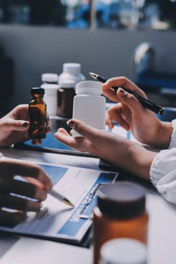 Hastane konferans salonunda kıdemli hekimin sunumu ve sağlık uygulamaları üzerine profesyonel eğitim oturumuna katılan bir grup doktor