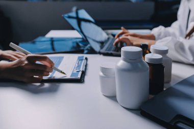 Hastane konferans salonunda kıdemli hekimin sunumu ve sağlık uygulamaları üzerine profesyonel eğitim oturumuna katılan bir grup doktor