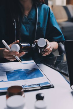 Hastane konferans salonunda kıdemli hekimin sunumu ve sağlık uygulamaları üzerine profesyonel eğitim oturumuna katılan bir grup doktor