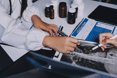 Hastane konferans salonunda kıdemli hekimin sunumu ve sağlık uygulamaları üzerine profesyonel eğitim oturumuna katılan bir grup doktor