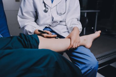 Rehabilitasyon terapisi, rehabilitasyon merkezlerinde çalışan profesyonel erkek fizyoterapistler, erkek hastaların bacak ve kas ağrılarını tedavi ederken,.