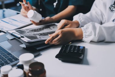 Hastane konferans salonunda kıdemli hekimin sunumu ve sağlık uygulamaları üzerine profesyonel eğitim oturumuna katılan bir grup doktor