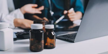 Hastane konferans salonunda kıdemli hekimin sunumu ve sağlık uygulamaları üzerine profesyonel eğitim oturumuna katılan bir grup doktor