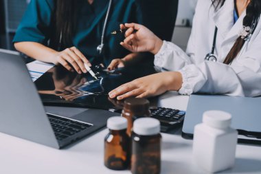 Hastane konferans salonunda kıdemli hekimin sunumu ve sağlık uygulamaları üzerine profesyonel eğitim oturumuna katılan bir grup doktor