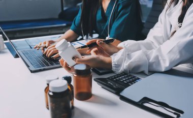 Hastane konferans salonunda kıdemli hekimin sunumu ve sağlık uygulamaları üzerine profesyonel eğitim oturumuna katılan bir grup doktor