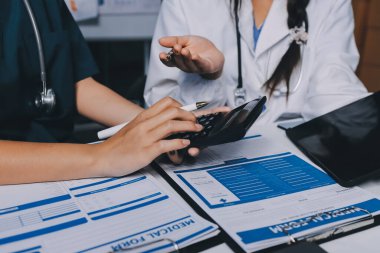 Hastane konferans salonunda kıdemli hekimin sunumu ve sağlık uygulamaları üzerine profesyonel eğitim oturumuna katılan bir grup doktor