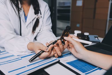 Hastane konferans salonunda kıdemli hekimin sunumu ve sağlık uygulamaları üzerine profesyonel eğitim oturumuna katılan bir grup doktor