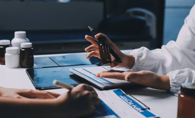 Hastane konferans salonunda kıdemli hekimin sunumu ve sağlık uygulamaları üzerine profesyonel eğitim oturumuna katılan bir grup doktor