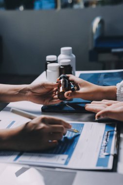 Hastane konferans salonunda kıdemli hekimin sunumu ve sağlık uygulamaları üzerine profesyonel eğitim oturumuna katılan bir grup doktor