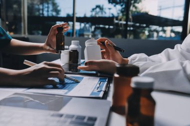 Hastane konferans salonunda kıdemli hekimin sunumu ve sağlık uygulamaları üzerine profesyonel eğitim oturumuna katılan bir grup doktor