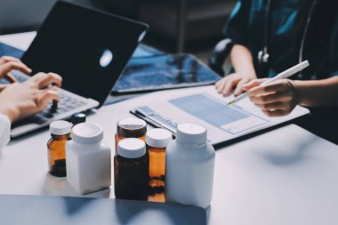 Hastane konferans salonunda kıdemli hekimin sunumu ve sağlık uygulamaları üzerine profesyonel eğitim oturumuna katılan bir grup doktor