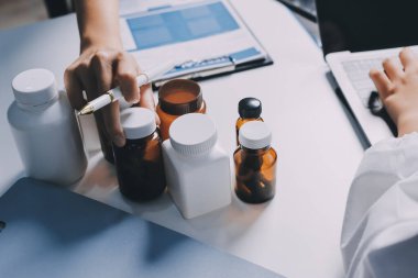 Hastane konferans salonunda kıdemli hekimin sunumu ve sağlık uygulamaları üzerine profesyonel eğitim oturumuna katılan bir grup doktor