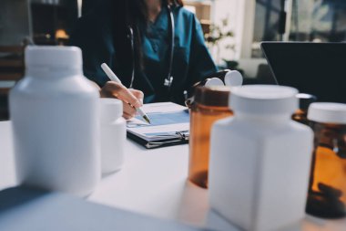 Hastane konferans salonunda kıdemli hekimin sunumu ve sağlık uygulamaları üzerine profesyonel eğitim oturumuna katılan bir grup doktor