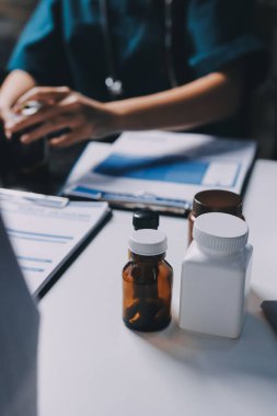 Hastane konferans salonunda kıdemli hekimin sunumu ve sağlık uygulamaları üzerine profesyonel eğitim oturumuna katılan bir grup doktor