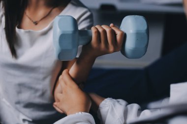 Fizyoterapistle antrenman yapan yaşlı bir kadın. Evde terapist kullanıyor. Huzurevinde yaşlı bir kadına destek oluyor.