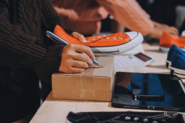 Asyalı bir kadın, sosyal ağda canlı yayında kıyafet satmayı sosyal medyada kıyafet satmayı anlatıyor. Blogger kadın nüfuzlu, KME perakende mağazası sahibi.