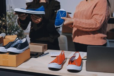 Asyalı bir kadın, sosyal ağda canlı yayında kıyafet satmayı sosyal medyada kıyafet satmayı anlatıyor. Blogger kadın nüfuzlu, KME perakende mağazası sahibi.