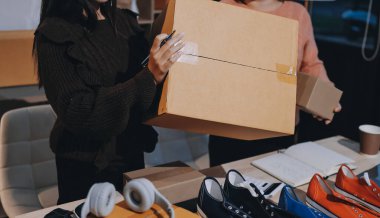 Asyalı bir kadın, sosyal ağda canlı yayında kıyafet satmayı sosyal medyada kıyafet satmayı anlatıyor. Blogger kadın nüfuzlu, KME perakende mağazası sahibi.