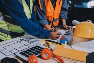Mimarlar ve mühendisler inşaat projesinde işbirliği içinde çalışıyorlar