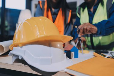 Mimarlar ve mühendisler inşaat projesinde işbirliği içinde çalışıyorlar