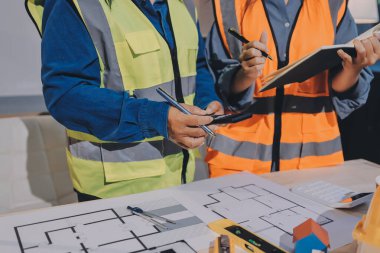 Mimarlar ve mühendisler inşaat projesinde işbirliği içinde çalışıyorlar
