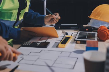 Mimarlar ve mühendisler inşaat projesinde işbirliği içinde çalışıyorlar