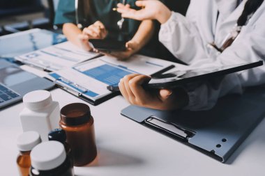 Hastane konferans salonunda kıdemli hekimin sunumu ve sağlık uygulamaları üzerine profesyonel eğitim oturumuna katılan bir grup doktor